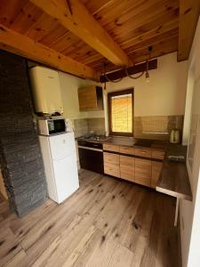 a kitchen with a white refrigerator and wooden floors at Chatka pod Stinskou in Zboj