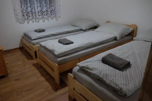 three twin beds in a room with wooden floors at Chatka pod Stinskou in Zboj