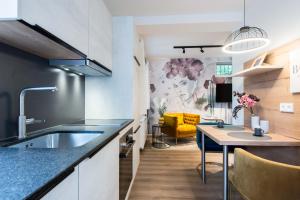 a kitchen with a sink and a table in a room at CHICLIVING Appartements in St. Wolfgang
