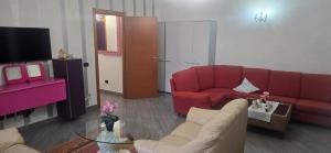 a living room with a red couch and a tv at Residenza dei pini lacchiarella in Lacchiarella