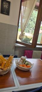 a table with a bowl of vegetables and a bowl of bread at Residenza dei pini lacchiarella in Lacchiarella