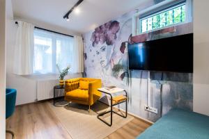 a living room with a yellow chair and a tv at CHICLIVING Appartements in St. Wolfgang
