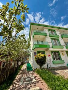 a white building with green trim next to a street at Dr Aslan Apart Hotel in Esenboga