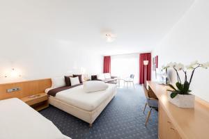 a hotel room with a bed and a desk at Hotel Höfli in Altdorf