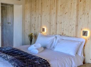 a bedroom with a bed with two towels on it at Bietjiedam's The Barn in Caledon