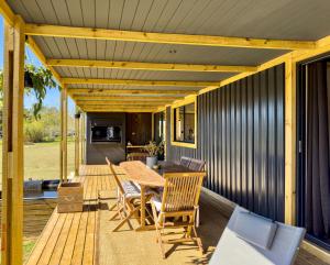 a wooden deck with a table and chairs at Bietjiedam's The Barn in Caledon