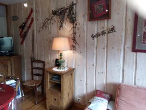 a room with a lamp on a wooden wall at STOP mon grand F2 face au parc des Écrins in Orcières