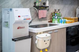 a small kitchen with a sink and a toilet at Muxuan Homestay in Yuli