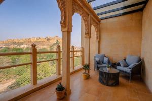 a room with two chairs and a large window at Hotel Aurea Jaisalmer in Jaisalmer