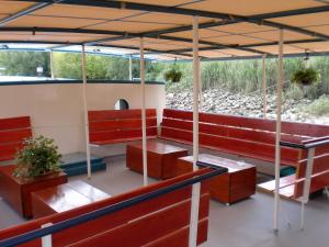 a room with a couch, chairs, and tables with umbrellas at Hotelboat Fiep in Amsterdam