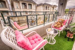 a balcony with pink chairs and a teddy bear on it at Muxuan Homestay in Yuli +13 photos