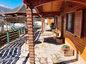 a porch of a house with a stone patio at Bujtina Anesi in Poliçan
