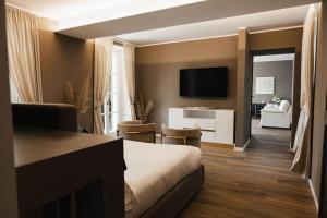 a hotel room with a bed and a living room at Villa Antica Colonia SPA & Wellness in Pettenasco