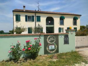a house with flowers in front of a fence at B&B Ca' Vecchia in Budrio