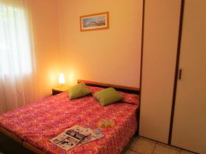 a bedroom with a bed with a red bedspread at Ville Verdi in Bibione