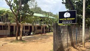 a sign on a fence in front of a building at Hasthi Resort in Polonnaruwa
