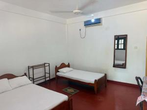 a room with two beds and a mirror at Hasthi Resort in Polonnaruwa