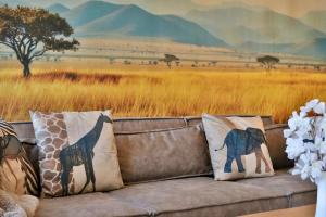 a couch with a safari mural on the wall at Zuri Suite in Rittersdorf