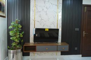 a television sitting on a dresser in a living room at Eifel Heights Apartments in Lahore