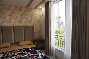 a bedroom with a view of the eiffel tower at Eifel Heights Apartments in Lahore