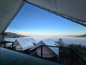 a view of the water from a building with a large window at เขาเจ้าขา-เต็นท์กระโจมเขาค้อ in Khao Kho