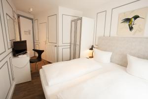 a white bedroom with a bed and a television at Boutique 056 Hamburg Central in Hamburg