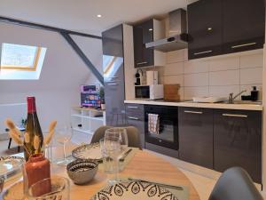 a kitchen with a table with a bottle of wine at Le cocon du Florival - Box à vélo - Guebwiller in Guebwiller