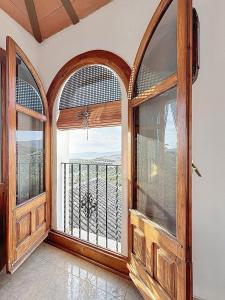 a room with two large wooden doors and a balcony at Torre Santo Dios in Iznájar