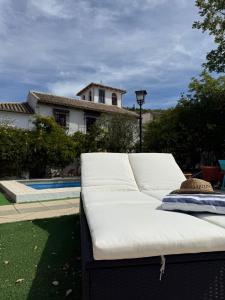 a white couch sitting in a yard next to a pool at Torre Santo Dios in Iznájar