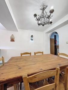 a dining room with a wooden table and a chandelier at Torre Santo Dios in Iznájar