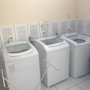 uma casa de banho com 2 lavatórios e 2 máquinas de lavar roupa em Hospedagem e kitnetes D' Itália em Curitiba