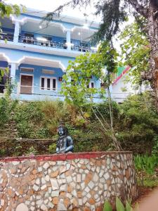 a statue sitting in front of a building at Dev Giri Guest House in Phata