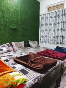 a room with a bed with a green wall at Dev Giri Guest House in Phata
