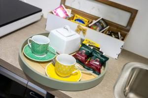 a table with two cups and plates and a box at ORIGINI - Dimora tra murgia e mare in Toritto +14 photos