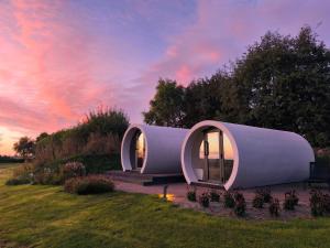a cylindrical house with two windows on a field at Boutique Hotel Texel in De Cocksdorp