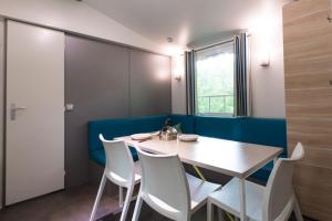 a dining room with a table and white chairs at Camping Het Veen in Brecht