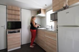 a woman standing in a kitchen preparing food at Camping Het Veen in Brecht