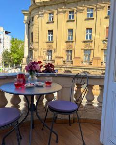 a table and chairs on a balcony with a building at Art Hotel Like in Zagreb