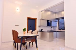 a kitchen and dining room with a table and chairs at Selora Suites Serviced Apartments in Mysore