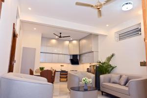 a living room with couches and a kitchen at Selora Suites Serviced Apartments in Mysore