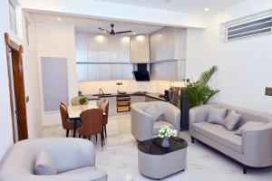 a living room with a table and a kitchen at Selora Suites Serviced Apartments in Mysore