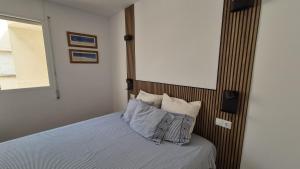a bedroom with a bed with white sheets and pillows at Comarruga Playa in Comarruga +12 photos
