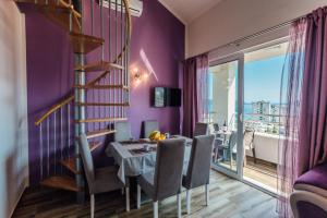 a dining room with a table and a purple wall at Apartments Anastasija in Herceg-Novi