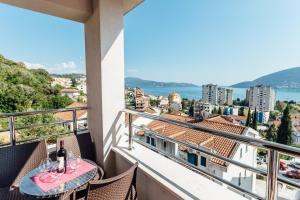 a balcony with a table and a view of the city at Apartments Anastasija in Herceg-Novi