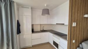 a kitchen with white cabinets and a sink at Comarruga Playa in Comarruga