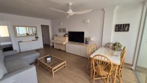 a living room with a couch and a table and a television at Comarruga Playa in Comarruga