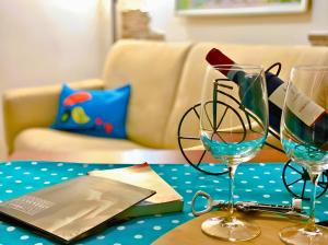 a table with two wine glasses and a laptop on it at The Best Nest in Rome