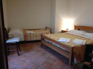 Habitación con 2 camas y una silla. en Il Fienile, en Barete