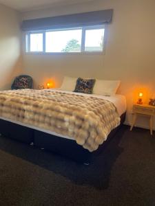 a large bed in a bedroom with a window at Gold Star Haven in Napier