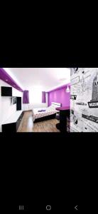 a living room with purple walls and a couch at Tiglina in Galaţi